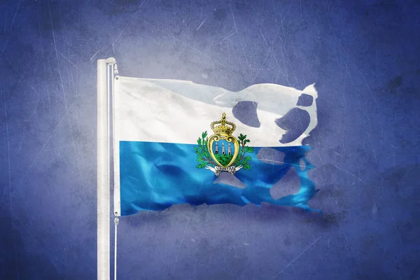 Torn flag of San Marino flying against grunge background — Stock Photo, Image