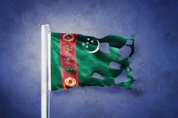 Torn flag of Turkmenistan flying against grunge background — Stock Photo, Image