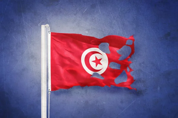 Sönderrivna flagga Tunisien flyger mot grunge bakgrund — Stockfoto