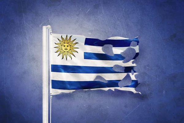 Torn flag of Uruguay flying against grunge background — Stock Photo, Image