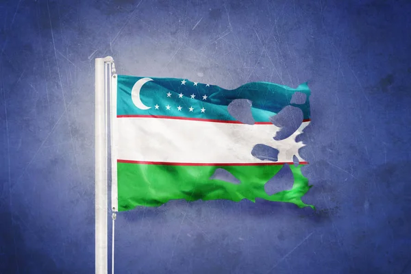 Zerrissene Flagge Usbekistans weht vor Grunge-Hintergrund — Stockfoto