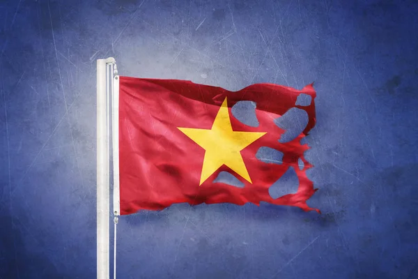 Torn flag of Vietnam flying against grunge background — Stock Photo, Image