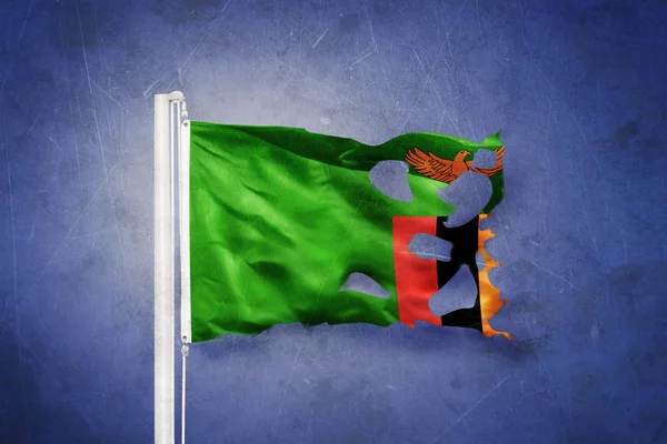 Sönderrivna flagga Zambia flyger mot grunge bakgrund — Stockfoto