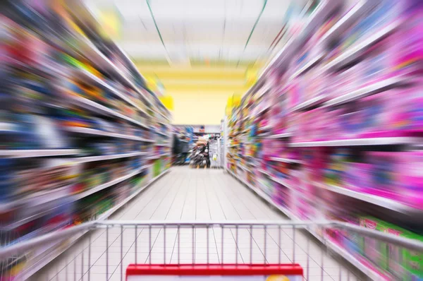 Nákupní košík pohled na supermarketu uličku a police - obraz má mělké hloubky ostrosti — Stock fotografie