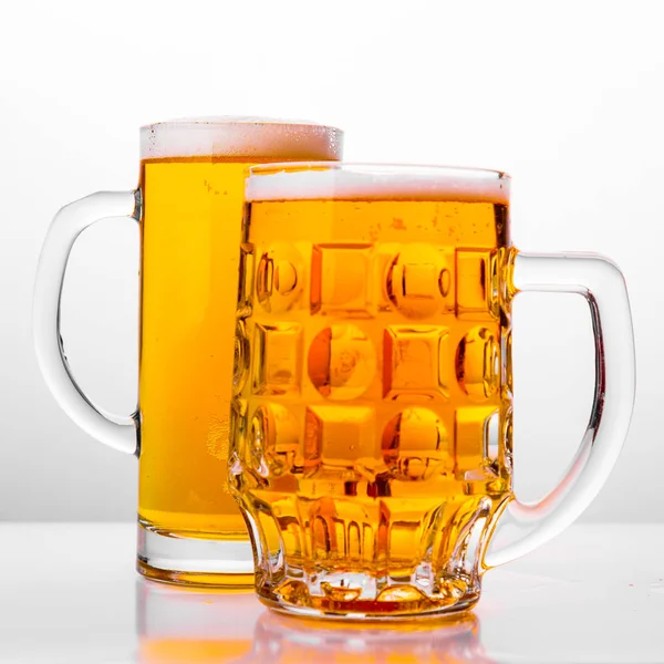 Two Mugs of fresh beer with cap foam — Stock Photo, Image