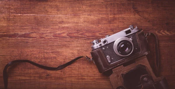 Ретро камера на дерев'яному столі фон вінтажний кольоровий тон — стокове фото