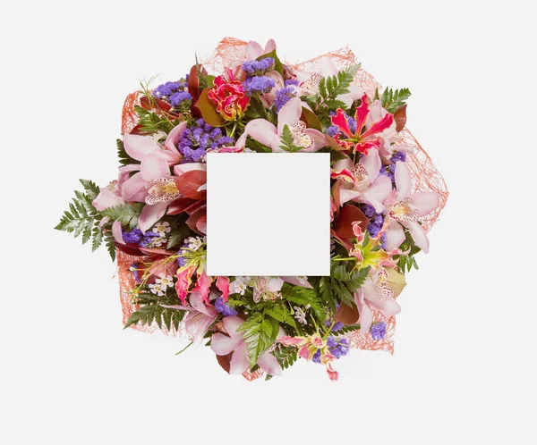 Creative layout made of flowers and leaves with paper card note. Flat lay — Stock Photo, Image