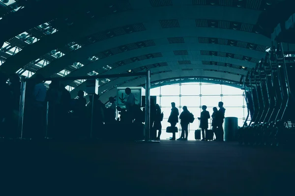 Traveling concept. Airport terminal blurred crowd of travelling people on the background. vintage color tone — Stock Photo, Image