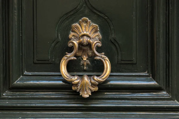 Old metal door handle knocker on a wooden background — Stock Photo, Image