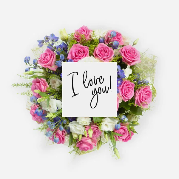 Fresh flowers bunch and card with words i love you written on it — Stock Photo, Image