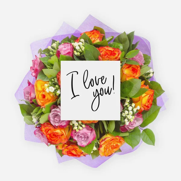 Fresh flowers bunch and card with words i love you written on it — Stock Photo, Image