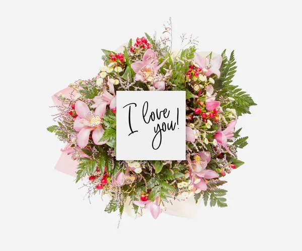 Fresh flowers bunch and card with words i love you written on it — Stock Photo, Image