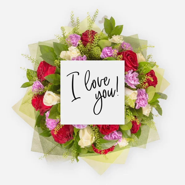 Fresh flowers bunch and card with words i love you written on it — Stock Photo, Image