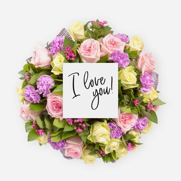 Fresh flowers bunch and card with words i love you written on it — Stock Photo, Image