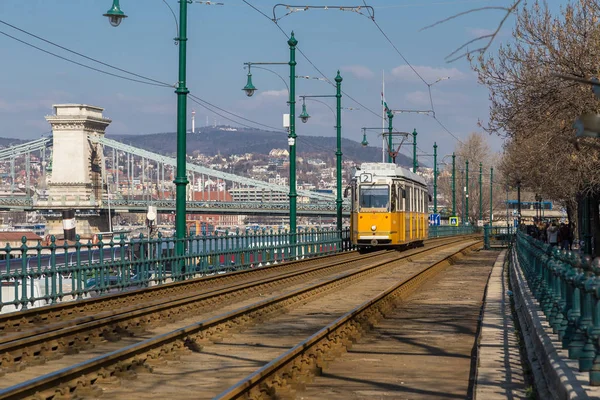 Budapest, Hungary, March 22 2018: Yellow Tram in early winter with cloudy sky. Tram number 2 is famous for being the best european line selected by National Geographic — Stock Photo, Image