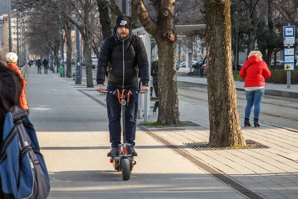 ブダペスト,ハンガリー, 2018年3月22日:若い男は、ヘルメットや保護なしで、高速で電動スクーターに乗っています。今日では、電動スクーターやスケートボードは嵐によって世界を乗っ取りました — ストック写真
