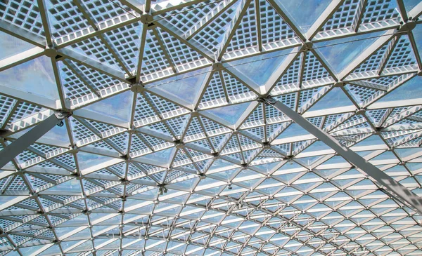 Abstrakte High-Tech-Architektur Hintergrundbild, innere Struktur des Glasdachbogens mit abschließbaren Fensterabschnitten. transparentes Glasdach eines modernen Gebäudes mit blauem Himmel und Wolken — Stockfoto