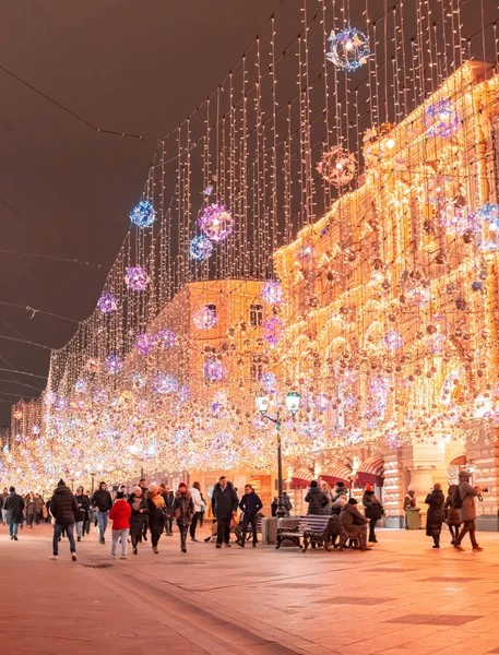 Moskva, Rusko - 27. listopadu 2019: Zlatý barevný déšť vánočních ozdob visících z oblohy, na Nikolské ulici vedle GUM v hlavním městě. Nikolská ulice osvětlena. Krásná světla — Stock fotografie