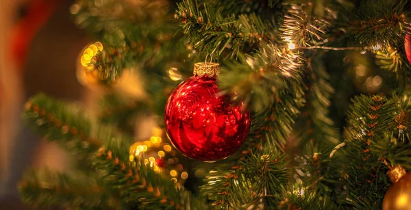 Albero di Natale con ornamenti di bagattelle d'oro. Primo piano decorato dell'albero di Natale. Palle e ghirlanda illuminata con torce elettriche. Capodanno bagattelle macro foto con bokeh. Vacanza invernale decorazione leggera — Foto Stock