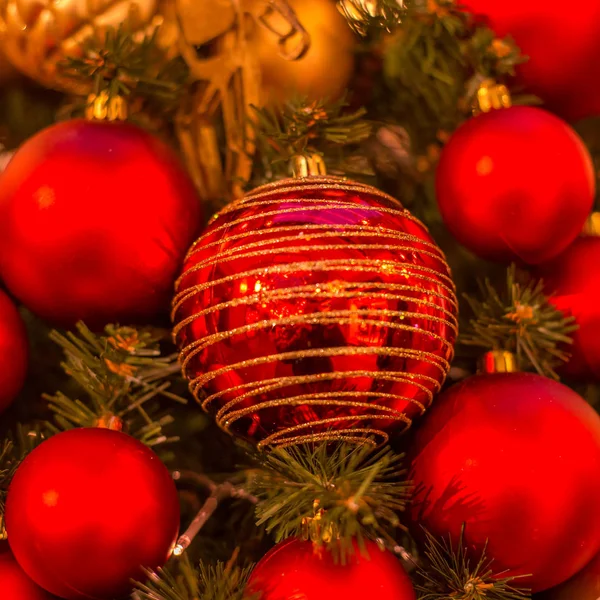 Árbol de Navidad con adornos de oro. Primer plano del árbol de Navidad decorado. Bolas y guirnalda iluminada con linternas. Año Nuevo bolas macro foto con bokeh. Decoración ligera vacaciones de invierno — Foto de Stock