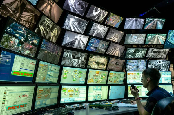 러시아 상트페테르부르크 - 2019 년 12 월 9 일: 여러 컴퓨터 화면을 보고 있는 사람의 뒷모습. 대규모 마켓 러시아 레이아웃 전시회에 여러 개의 디스플레이가 있는 감시 시스템 — 스톡 사진