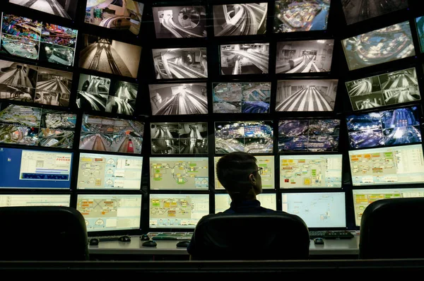 Saint-Pétersbourg, Russie - 9 décembre 2019 : Vue arrière d'un homme regardant plusieurs écrans d'ordinateur. Système de surveillance avec plusieurs affichages sur l'exposition de la disposition Grand maket Russie — Photo