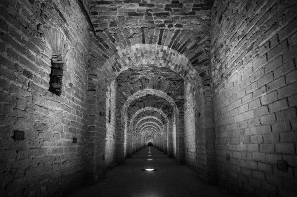 Arco del túnel de ladrillo hecho de ladrillos rojos como un pasaje entre las dos alas de un castillo medieval. Piedra de granito un ladrillo construido corredor interior camino a los bastiones — Foto de Stock