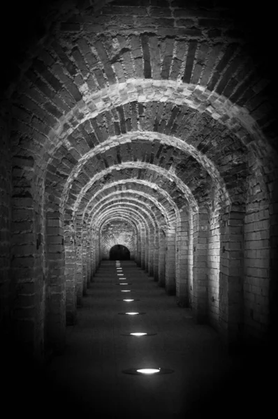 中世の城の2つの翼の間の通路として赤レンガで作られたレンガ造りのトンネルアーチ。花崗岩の石レンガ造り基礎への内部廊下道を構築 — ストック写真