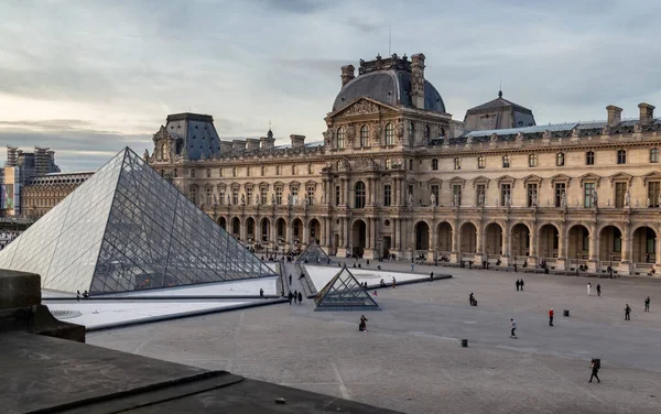 París, Francia - 29 de marzo de 2017: Vista del famoso Museo del Louvre con la Pirámide del Louvre por la noche. Museo del Louvre es uno de los museos más grandes y visitados en todo el mundo — Foto de Stock
