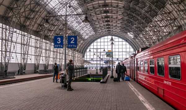 俄罗斯莫斯科- 2013年3月23日：覆盖的基辅火车站月台。红色火车快车开往机场.在莫斯科Kievsky火车站Aero特快列车旁边的月台上的乘客 — 图库照片