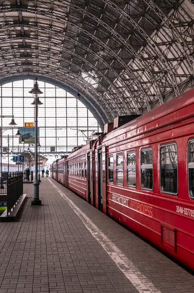 Moscow, Russia - March 23, 2013: Covered platform of Kievsky railway station. Red train aeroexpress to airport. People on the platform beside the Aero express train at Kievsky railway station Moscow — Stock Photo, Image