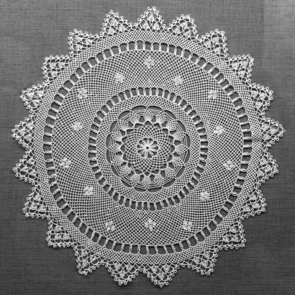 Handmade lace on black background. Macrame fabric lace doily. Crocheted white lace decorative napkin — Stock Photo, Image