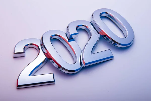 Gott nytt år 2020. Symbol från nummer 2020 på ljus bakgrund. Silverbokstäver i form av siffror 2020. Stockbild