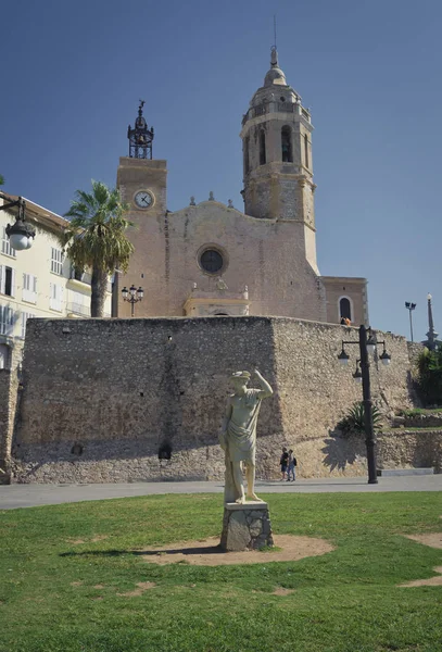 Статуя человека против церкви Сан-Бартомеу и Санта-Текла в — стоковое фото