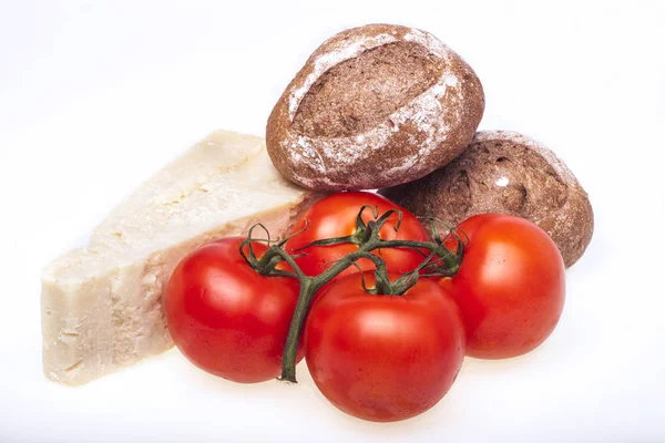 Tomatoes, cheese parmesan and dark rolls — Stock Photo, Image