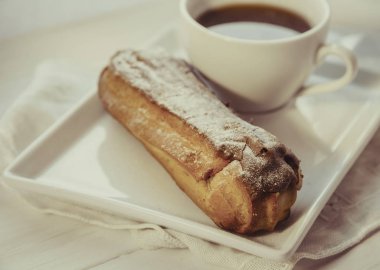 Tabakta çikolatalı ekler ve bir fincan kahve.