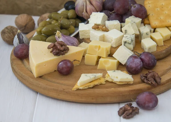 Piatto di formaggio con uva, olive e noci — Foto Stock