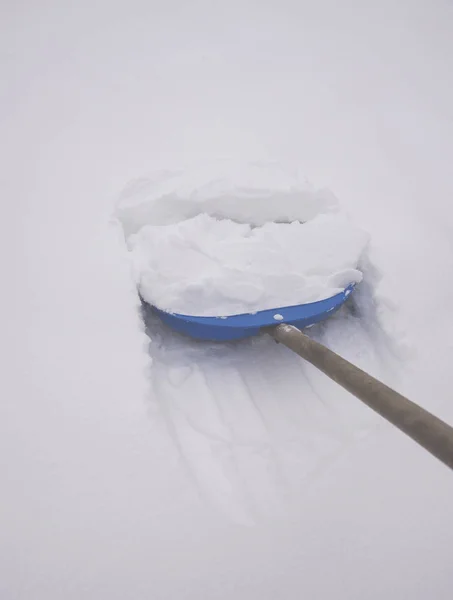 在白雪中的铲子 用铲子擦雪 — 图库照片