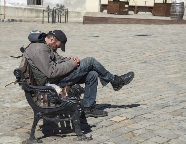 リヴィウ市の路上で、ベンチで寝ているホームレスの男性 — ストック写真