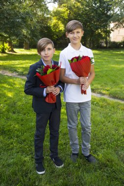 Çocuklar parkta gül demetleri ile