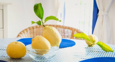 Masada yaprakları olan taze limonlar.