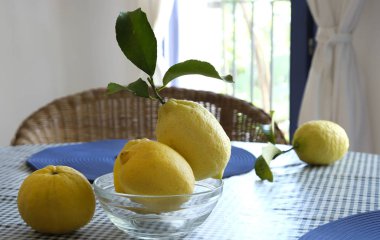 Masada yaprakları olan taze limonlar.