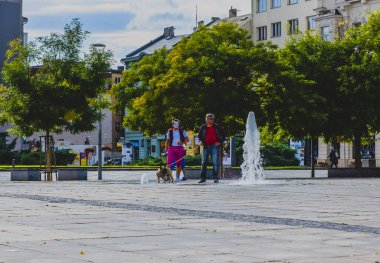 OSTRAVA / CZECH REPUBLIC - SEPTEMBER 29, 2019: A man with a dog in the Central square of Ostrava city - Masaryk Square