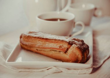 Tabakta çikolatalı ekler ve bir fincan kahve.