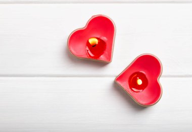 Mum beyaz masada iki kırmızı kalp şeklinde,