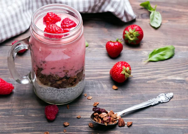 Chia pudding with granola and strawberries in a glass jar on the — Stock Photo, Image