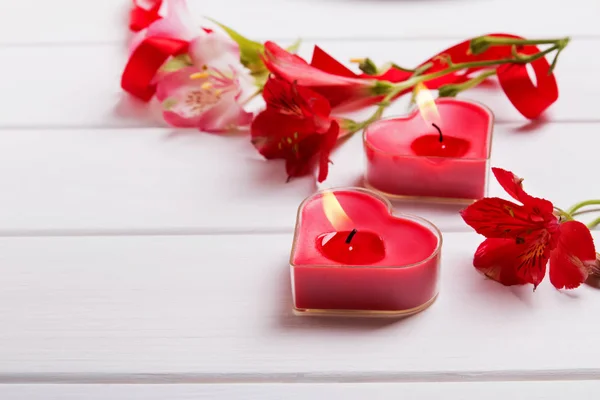 Két szív alakú gyertyák és virágok alstromeria — Stock Fotó