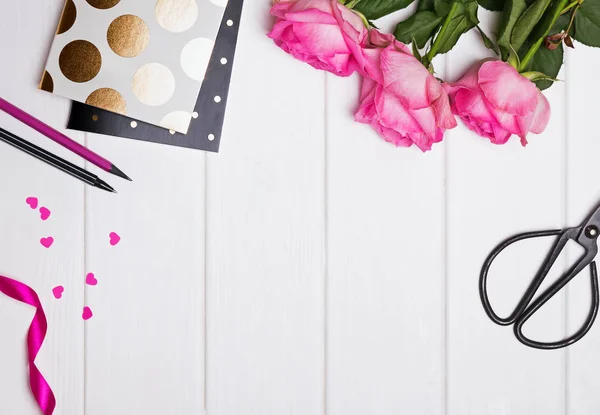 Roze rozen, blocnotes met gouden polka dot, papier hartjes en andere — Stockfoto