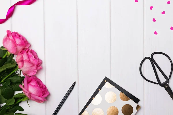 Roze rozen, blocnotes met gouden polka dot, papier hartjes en othe — Stockfoto