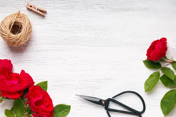 红玫瑰，黄麻绳子和剪刀在桌子上，顶视图 — 图库照片
